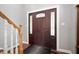 Interior view of the elegant front door, complemented by side windows and a staircase with wooden banister at 9910 Suncoral Cir, Fishers, IN 46038