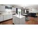 Open concept kitchen with white cabinets, center island, and seamless flow into the living room area at 9910 Suncoral Cir, Fishers, IN 46038