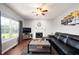 Comfortable living room with a fireplace, large window, and a stylish leather sectional sofa at 9910 Suncoral Cir, Fishers, IN 46038