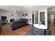 Cozy living room with a fireplace, black leather furniture, hardwood floors, and neutral gray wall paint at 9910 Suncoral Cir, Fishers, IN 46038