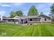 Lush green backyard featuring deck with outdoor furniture and screened-in porch at 10444 Collingswood Ln, Fishers, IN 46037