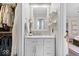 Bathroom vanity, mirror, drawers, and open closet with clothes on hangers at 10444 Collingswood Ln, Fishers, IN 46037