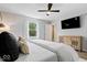 Modern bedroom with a ceiling fan, TV, and view from the window at 10444 Collingswood Ln, Fishers, IN 46037
