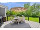 Deck with outdoor dining set and umbrella, perfect for enjoying the beautiful backyard at 10444 Collingswood Ln, Fishers, IN 46037