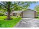 Beautiful single-story home featuring a two-car garage, a manicured lawn, and mature landscaping at 10444 Collingswood Ln, Fishers, IN 46037