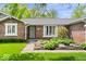 Beautiful brick home featuring a charming front garden and lush green lawn at 10444 Collingswood Ln, Fishers, IN 46037