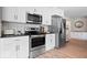 Close-up of the kitchen featuring stainless steel appliances, white cabinets, and modern countertops at 10444 Collingswood Ln, Fishers, IN 46037