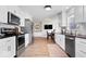 Modern kitchen boasts white cabinets, stainless appliances, and a stylish dining area at 10444 Collingswood Ln, Fishers, IN 46037