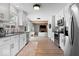 Modern kitchen with white cabinets, stainless steel appliances, and hardwood floors at 10444 Collingswood Ln, Fishers, IN 46037