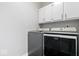 Laundry room with front load washer and dryer under cabinets for storage at 10444 Collingswood Ln, Fishers, IN 46037