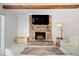 Cozy living room showcasing a brick fireplace and exposed wood beams at 10444 Collingswood Ln, Fishers, IN 46037