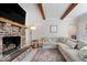 Warm living room with a brick fireplace, wooden beam accents, and ample seating at 10444 Collingswood Ln, Fishers, IN 46037