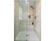 Modern bathroom shower with glass doors, a tile surround, and rainfall shower head at 10444 Collingswood Ln, Fishers, IN 46037