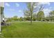 Expansive backyard with lush green grass, mature trees, and white fence, perfect for outdoor activities at 10616 Bartley Dr, Indianapolis, IN 46236