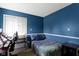 Bright bedroom featuring blue walls, comfortable bed, and a functional desk with natural light at 10616 Bartley Dr, Indianapolis, IN 46236