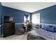 Cozy bedroom with blue walls, comfortable bed, and functional desk area for work or study at 10616 Bartley Dr, Indianapolis, IN 46236