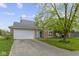 Charming single-story home featuring a two-car garage and a well-maintained lawn with mature tree at 10616 Bartley Dr, Indianapolis, IN 46236