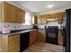 Functional kitchen with wooden cabinets, black appliances, and laminate countertops at 10616 Bartley Dr, Indianapolis, IN 46236