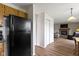 A view from the kitchen into the living room featuring a black refrigerator and wood burning fireplace at 10616 Bartley Dr, Indianapolis, IN 46236