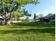 Lush backyard featuring mature trees, green lawn and access to a covered deck at 10751 N Kitchen Rd, Mooresville, IN 46158