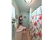 Small bathroom with a floral shower curtain, small mirror and open shelf for storage at 10751 N Kitchen Rd, Mooresville, IN 46158