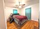 Cozy bedroom featuring hardwood floors, ceiling fan, and a comfortable bed with a plaid blanket at 10751 N Kitchen Rd, Mooresville, IN 46158