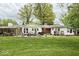 Spacious backyard with a well-manicured lawn, large trees, and outdoor furniture for relaxation and entertainment at 10946 Maze Rd, Indianapolis, IN 46259