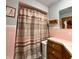 Bathroom with pink tile featuring a shower with patterned curtain and vanity at 10946 Maze Rd, Indianapolis, IN 46259