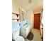 Bathroom with blue tile backsplash, open wood shelving, and tiled floor at 10946 Maze Rd, Indianapolis, IN 46259