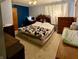 Bedroom with blue accent wall, white curtained window, and a patterned blanket on the bed at 10946 Maze Rd, Indianapolis, IN 46259