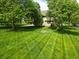 Serene backyard view with neatly striped lawn and mature trees creating a private oasis at 11021 Brentwood Ave, Zionsville, IN 46077