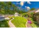 Serene backyard with a winding brick path, lush lawn, mature trees, and charming shed at 1120 Crystal Ct, Avon, IN 46123