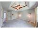 A modern bedroom with a tray ceiling, ceiling fan, and stylish sconces at 1120 Crystal Ct, Avon, IN 46123