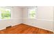 Bedroom with wood floors, white walls with trim, and two windows at 11603 Peacock Dr, Indianapolis, IN 46236