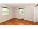 Bedroom featuring wood floors, white walls, green window trim, and a vintage vent at 11603 Peacock Dr, Indianapolis, IN 46236