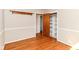 Bedroom with wood floors, white walls with white trim, closet with wood door and shelving at 11603 Peacock Dr, Indianapolis, IN 46236
