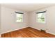 Bedroom with wood floors, white walls, green window trim, and bright natural light at 11603 Peacock Dr, Indianapolis, IN 46236
