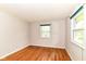 Bedroom with wood floors, white walls, green window trim, and natural light at 11603 Peacock Dr, Indianapolis, IN 46236