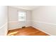 Bedroom with wood floors, white walls with white trim, a small window, and updated vent at 11603 Peacock Dr, Indianapolis, IN 46236