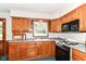 Traditional-style kitchen featuring wood cabinets, laminate countertops, and a double basin sink beneath a window at 11603 Peacock Dr, Indianapolis, IN 46236