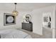 Bright bedroom featuring a dandelion wall art, dresser with mirror, and open doorway to a hall at 11840 Vale St, Indianapolis, IN 46235