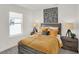 Bedroom with a stylish gray bed frame, bright window, and modern bedside lamps at 11840 Vale St, Indianapolis, IN 46235