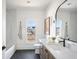 Modern bathroom features a tub, single vanity, and a window overlooking the neighborhood at 11904 Spring Mill Rd, Carmel, IN 46032