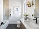 Bright bathroom featuring a modern vanity, sleek black faucet, and stylish hexagon floor tiles at 11904 Spring Mill Rd, Carmel, IN 46032