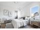 Bright bedroom with natural light, featuring a bed with gray accents, artwork, and a small seating area at 11904 Spring Mill Rd, Carmel, IN 46032