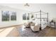 Bright bedroom with a four-poster bed, seating area, hardwood floors, and large windows overlooking the outdoors at 11904 Spring Mill Rd, Carmel, IN 46032