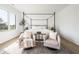Bright bedroom featuring a four-poster bed with decorative pillows, bedside tables, and a seating area at 11904 Spring Mill Rd, Carmel, IN 46032