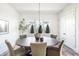 Bright dining room features a wood table, modern chandelier, large window, and neutral decor at 11904 Spring Mill Rd, Carmel, IN 46032