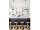 Kitchen island with bar stools and white cabinets, featuring modern pendant lights at 11904 Spring Mill Rd, Carmel, IN 46032