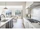 Bright kitchen with stainless steel appliances and view to the living room featuring hardwood floors and plentiful natural light at 11904 Spring Mill Rd, Carmel, IN 46032